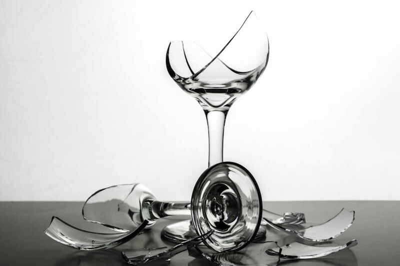 Two Broken Champagne Wine Glasses  with shards of glassand shattered glass on White Background