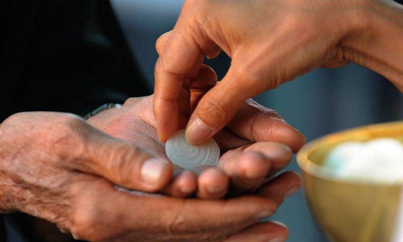 Malaysian Christians participate in the communion rite at a Sunday service inside a church in Petaling Jaya near Kuala Lumpur on January 10, 2010. Malaysian Christians turned up to Sunday services in their thousands, presenting a united front of defiance in the face of a series of church firebombings that has heightened ethnic tensions. Four churches have been targeted since January 8 amid an escalating row over the use of the word "Allah" as a translation for the Christian God by non-Muslims in the Muslim-majority nation. AFP PHOTO/Saeed KHAN (Photo credit should read SAEED KHAN/AFP/Getty Images)